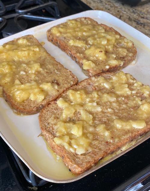 Banana French toast battered and cooking on the pan