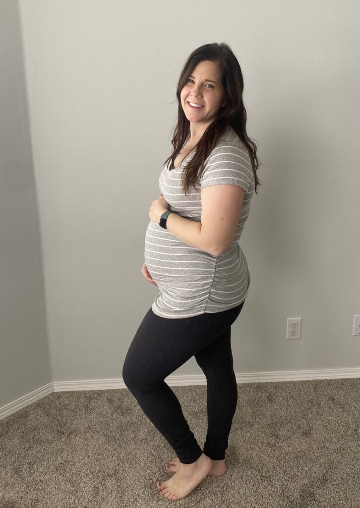 Pregnant mom holding belly in second trimester. 