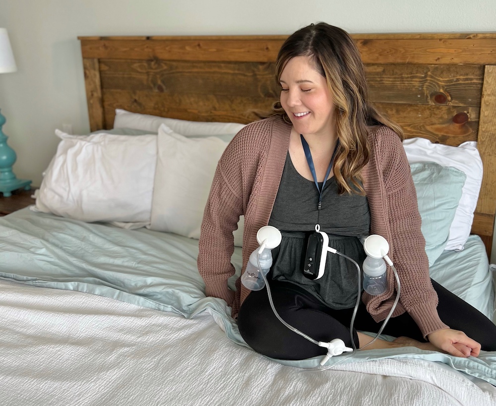 Sitting on bed with Baby Buddha Breast Pump