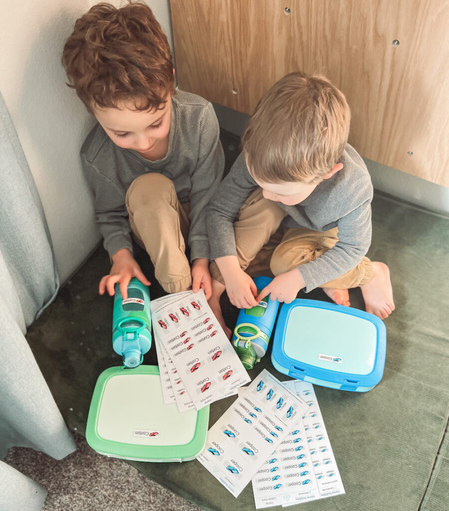 Boys looking at lunch boxes and name bubbles