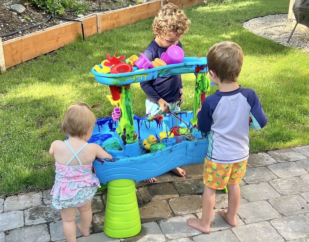 Kids painting the water table - messy outdoor play