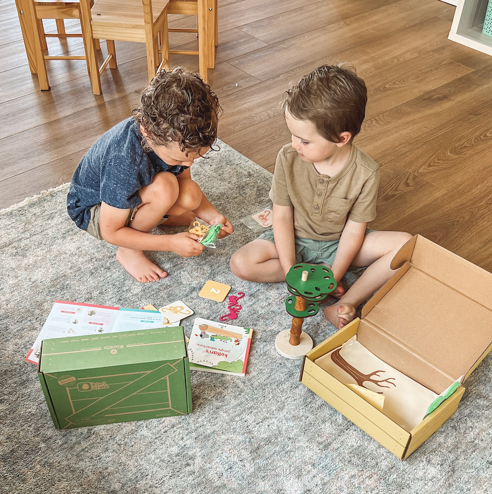 Two boys sitting with KiwiCo Learning Toys