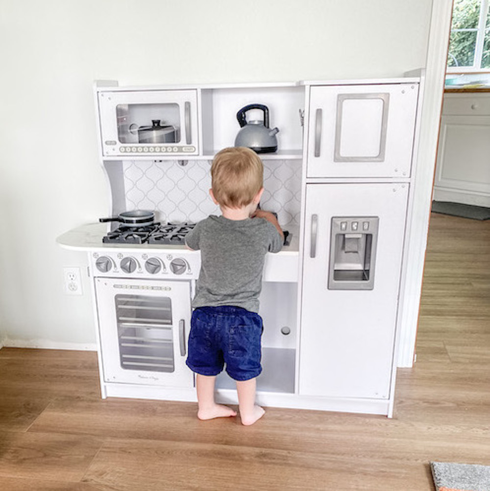 Boy playing with montessori kitchen