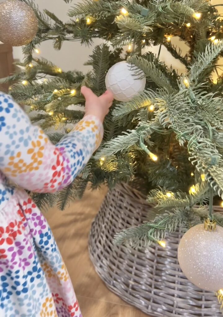 toddler putting up Christmas ornaments
