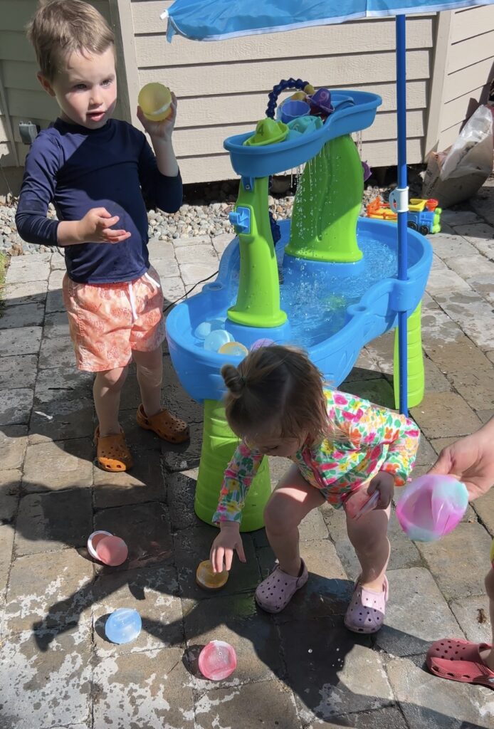 kids playing with water table and accessories